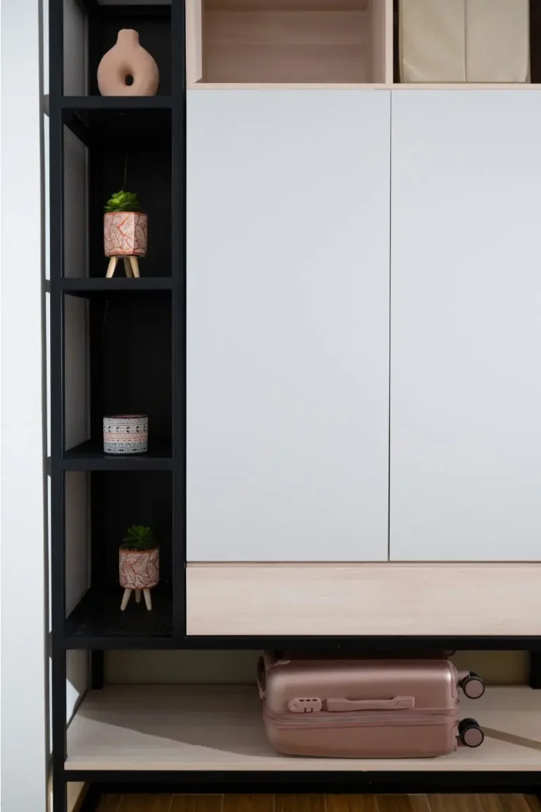 Close-up of a custom industrial wardrobe with a suitcase storage area and decorative shelving at Ria's Apartment in Agios Nikolaos.