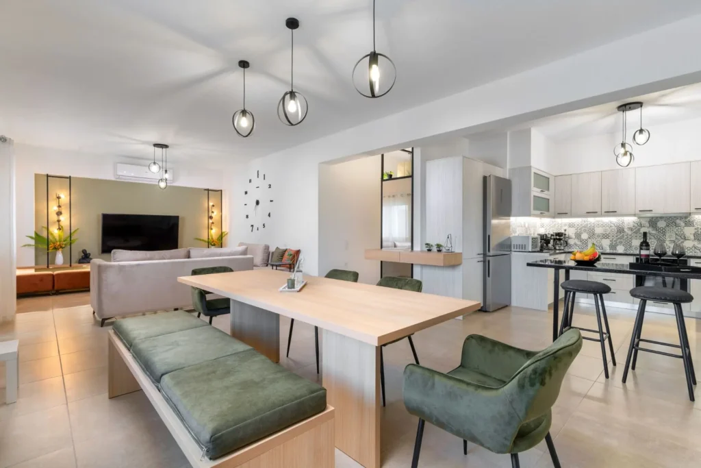 Wide view of open-plan dining room, modern kitchen, and living room at Ria's Apartment in Agios Nikolaos, Crete.