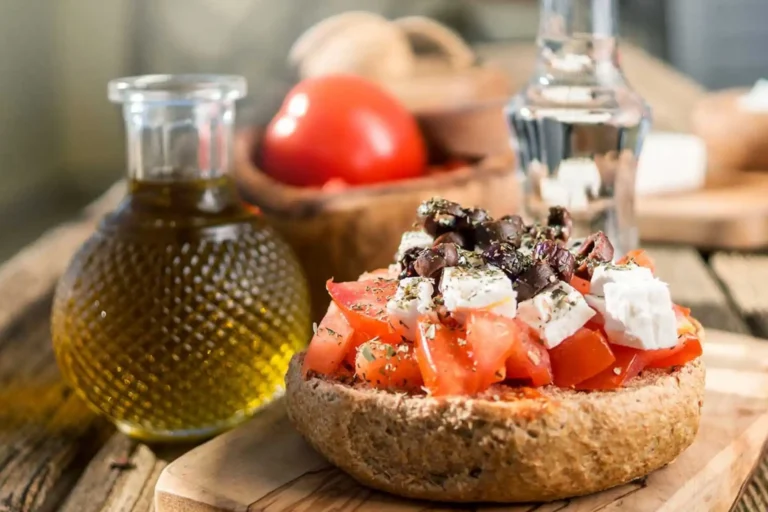 Παραδοσιακός κρητικός ντάκος με ψιλοκομμένη ντομάτα, φέτα, ελιές, ρίγανη και ελαιόλαδο πάνω σε ξύλινο ξύλο κοπής.