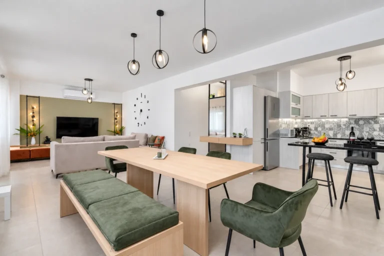 Wide view of open-plan dining room, modern kitchen, and living room at Ria's Apartment in Agios Nikolaos, Crete.