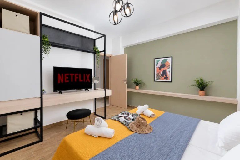 Interior view of the second bedroom at Ria Oasis Residence in Agios Nikolaos, featuring a smart TV with Netflix, a custom wardrobe, and a double bed.