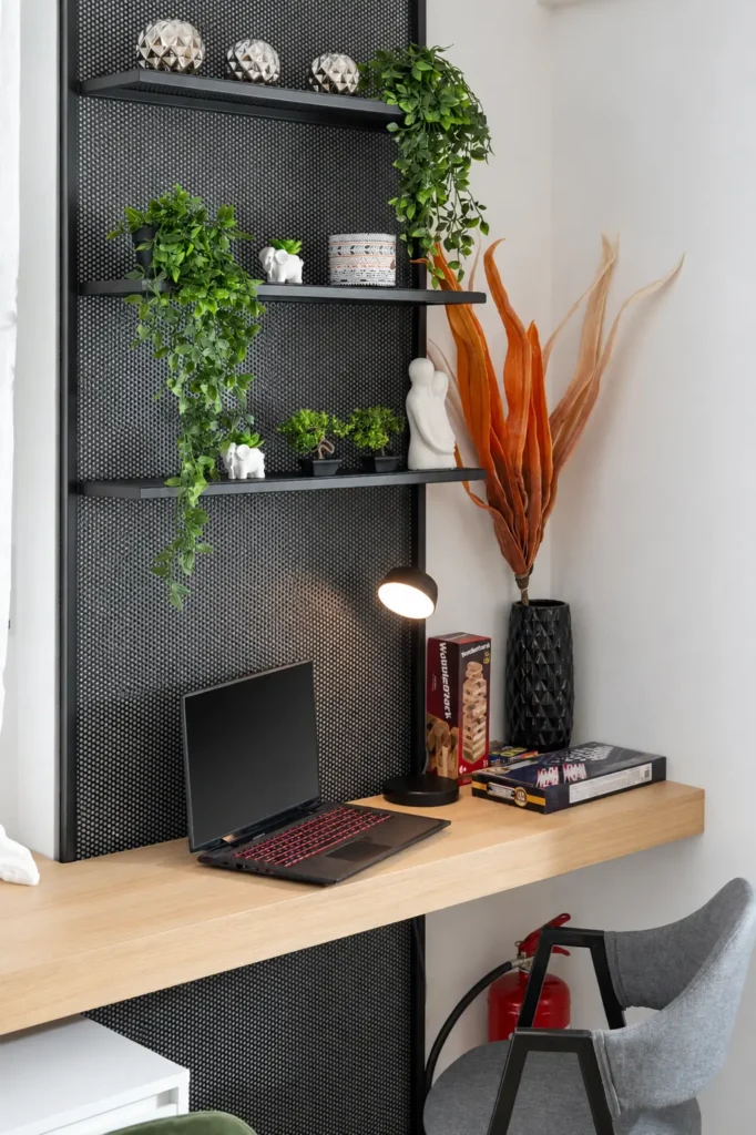 Close-up of a modern wooden desk with a laptop, office chair, and industrial shelving at Ria Oasis Residence in Agios Nikolaos.