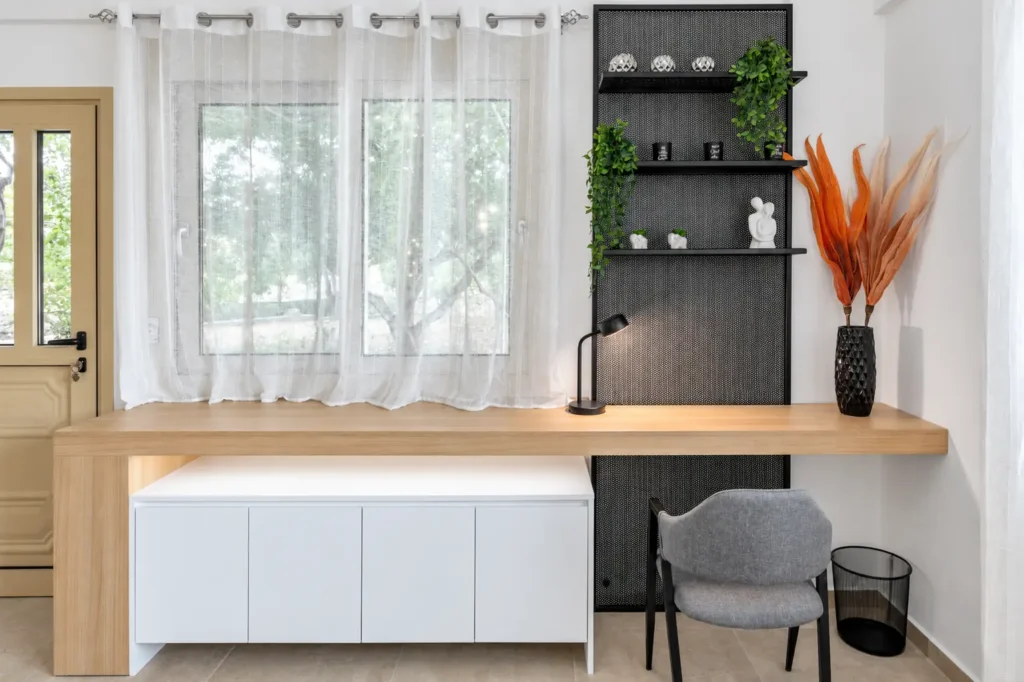 Dedicated remote workspace with a wooden desk, office chair, industrial shelving, and Starlink internet at Ria's Apartment in Agios Nikolaos.